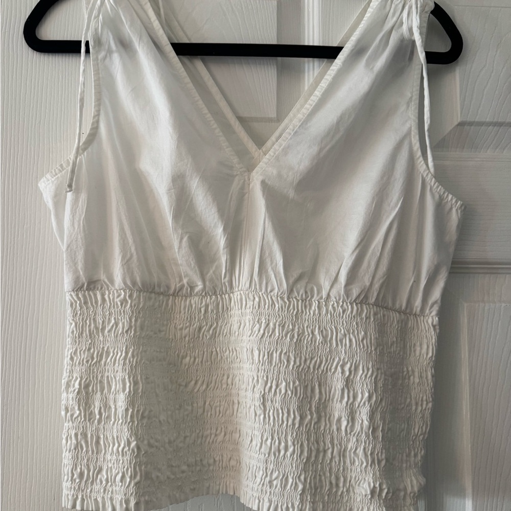 White Sleeveless Top. Deep V front & back. Smocked bottom Faux ties at shoulder